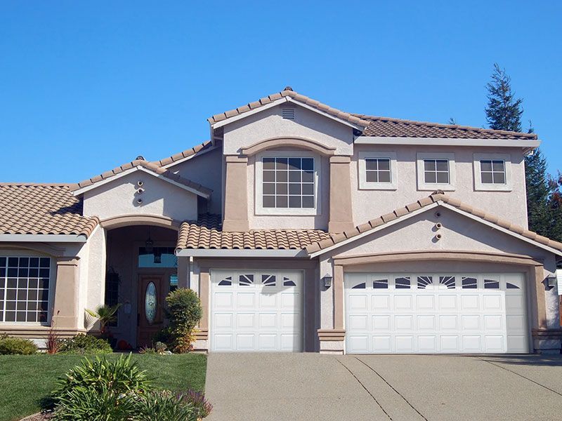 beige home exterior with white garage doors