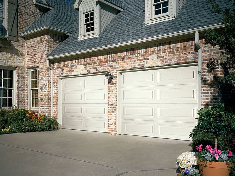 beige home exterior with white garage doors